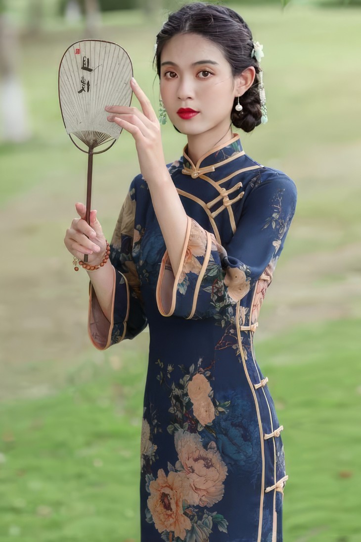 Qipao largo azul marino con motivos florales vintage, mangas tres cuartos y cuello mandarin, vista frontal con abanico chino