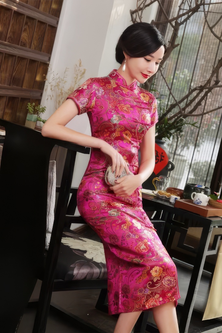 Qipao largo rosa fucsia de satén con motivos florales y cachemira dorada, cuello mandarin y mangas cortas, vista lateral de detalle