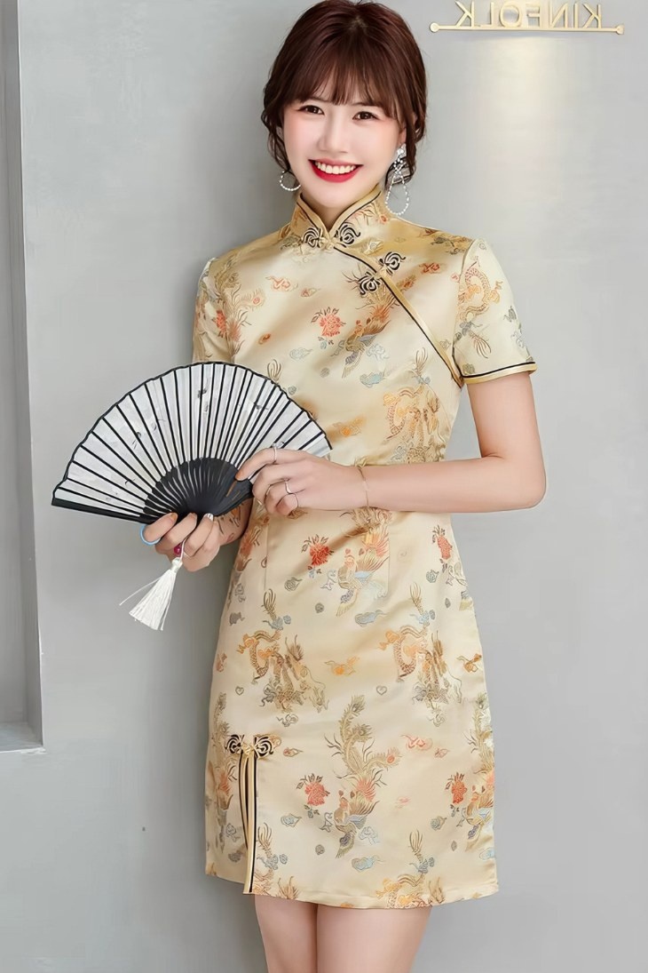 Vestido chino corto dorado de satén con motivos florales y dragón, cuello mandarin y mangas cortas, vista frontal con abanico negro