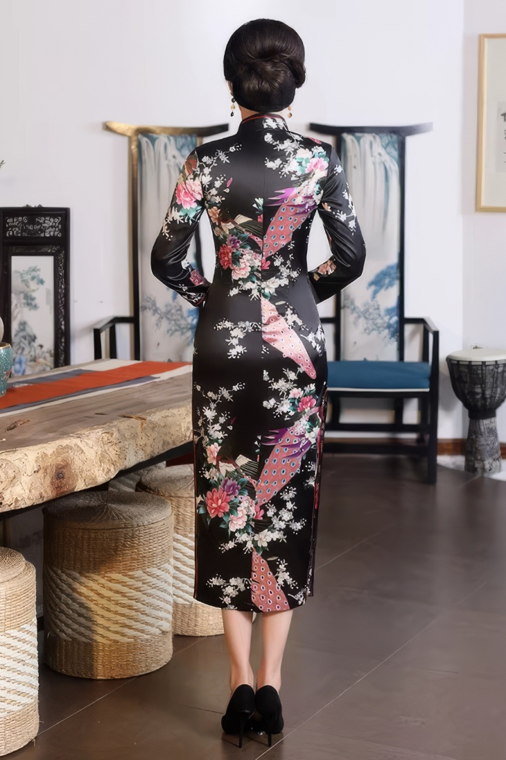 Vestido chino largo negro de satén con motivos de pavo real y flores visto desde atrás, mangas tres cuartos y cuello mandarin
